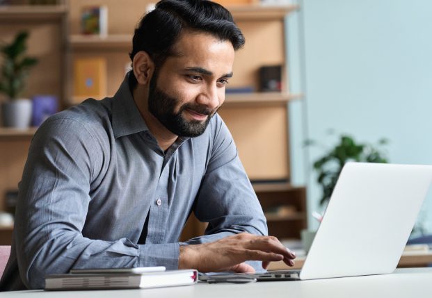 Business Man using computer in office smiling